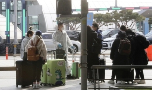 지난 2월 25일 인천국제공항에서 보호복과 방진 마스크 등으로 중무장한 중국인 유학생들이 이동 차량을 기다리고 있다. 영종도=연합뉴스