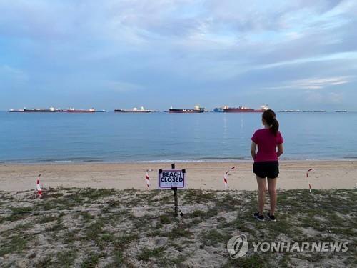 싱가포르에서 한 여성이 폐쇄된 해변을 바라보고 있다. 2020.4.11 [로이터=연합뉴스]