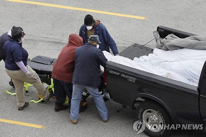 19일 미국 필라델피아 검시소 주차장에서 인부들이 픽업트럭에 실린 시신을 내리는 모습 [AP=연합뉴스]
