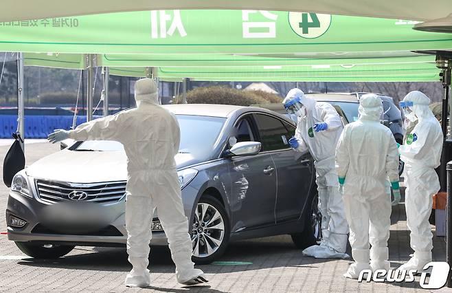지난 3월24일 서울 송파구 잠실종합운동장 주경기장에 설치된 신종 코로나바이러스 감염증(코로나19) 서울시 승차검진 선별진료소에서 시민들이 차량에 탄 채 검사를 받고 있다. 20203.24/뉴스1 © News1 성동훈 기자