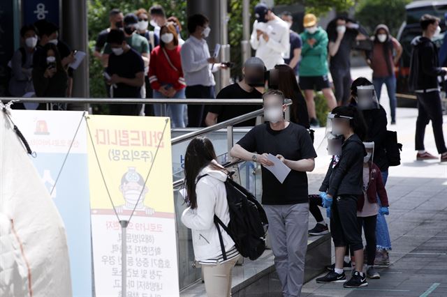 11일 서울 용산구 보건소에 마련된 선별진료소에 시민들과 외국인들이 줄 서 있다. 뉴스1