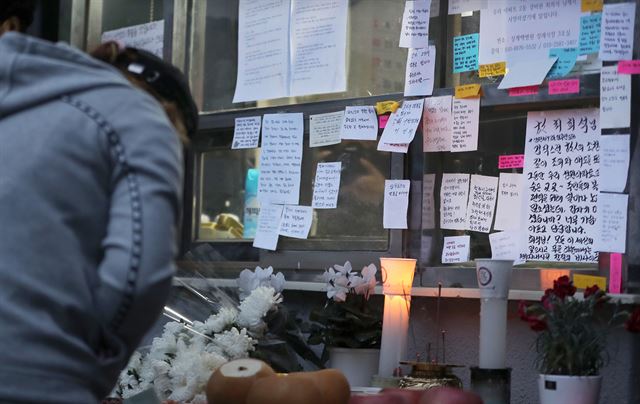 아파트 입주민들이 11일 서울 강북구 한 아파트 경비실 앞에서 전날 숨진 경비원 최모씨를 추모하고 있다. 뉴시스