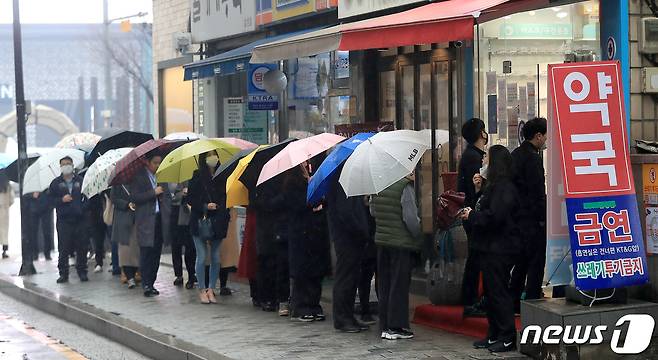 마스크 5부제 시행 이틀째인 10일 서울 강남구 테헤란로의 한 약국에서 우산을 쓴 시민들이 마스크를 사기 위해 줄을 서고 있다. 2020.3.10/뉴스1 © News1 구윤성 기자