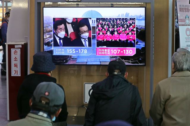 21대 국회의원 선거일인 지난달 15일 오후 서울역에서 유권자들이 방송3사 출구조사 결과를 지켜보고 있다. 뉴스1