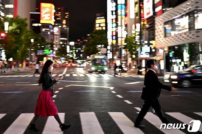 지난 20일 오후 일본 도쿄에서 마스크를 착용한 시민들이 길을 건너고 있다. © AFP=뉴스1