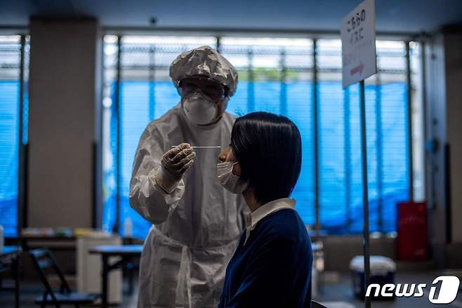 지난 8일 일본 도쿄에서 의료용 방호복을 입은 의료진이 코로나19 검체 채취를 시연하고 있다. © AFP=뉴스1