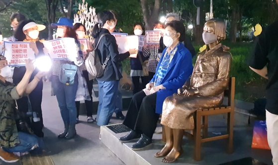 일본군 위안부 피해자 이용수 할머니가 지난달 27일 밤 대구에서 열린 수요시위에 참석해 소녀상 곁에 앉아 있다. 연합뉴스