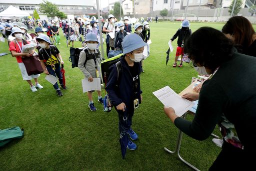 일본 도쿄 초등학생들이 신종 코로나바이러스 감염증(코로나19) 긴급사태 해제 1주일이 지난 1일 등교를 시작해 운동장에서 코로나19 예방 건강 문진표를 제출하고 있다. 도쿄 AFP=연합뉴스