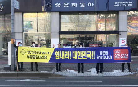 쌍용차 직원들이 지난 4월 15일 인천에서 신종 코로나 바이러스 감염증(코로나19) 극복 길거리 응원 캠페인을 하고 있다. (사진=쌍용자동차)