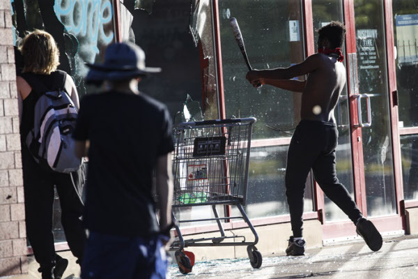 미네소타 세인트 폴에서 한 흑인이 상점의 유리창을 야구방망이로 깨고 있다/AP 연합뉴스