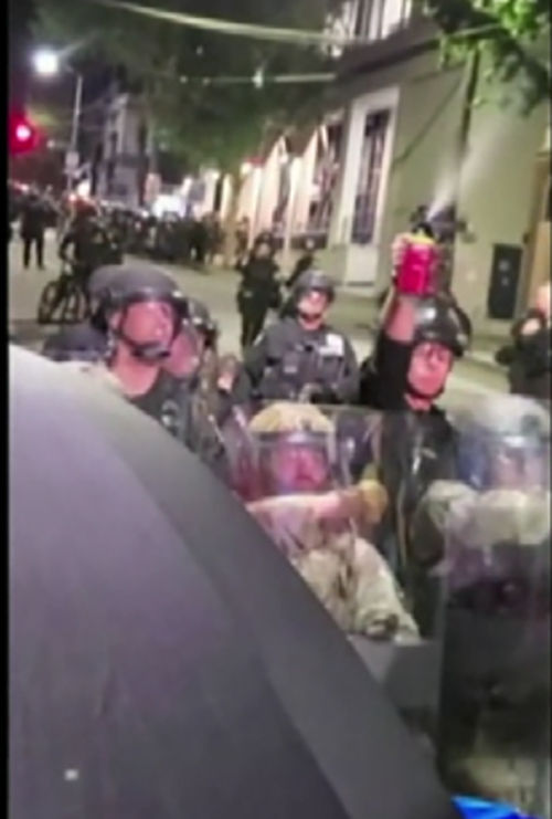페퍼 스프레이를 뿌리는 경찰과 우산으로 막는 시위대
