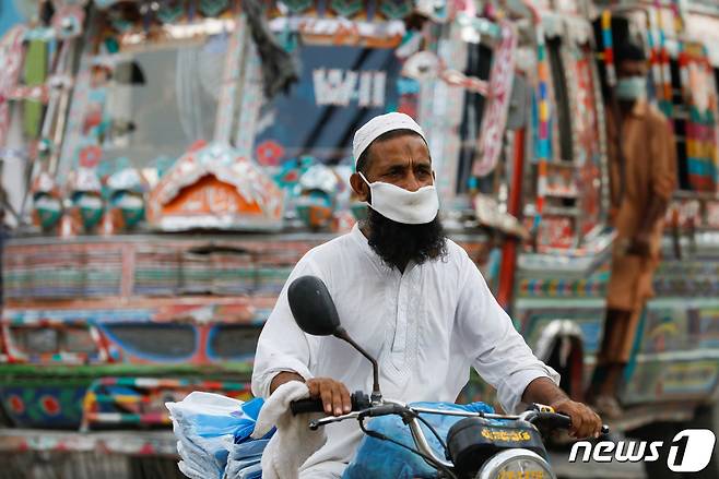 파키스탄 남부 카라치에서 한 남성이 마스크를 쓴 채 오토바이를 타고 있다. © 로이터=뉴스1