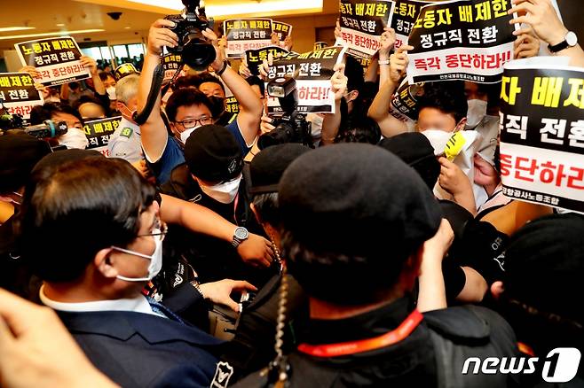 구본환 인천국제공항공사 사장이 22일 오후 인천공항1터미널에서 열린 기자회견에서 정규직 전환에 대한 입장을 밝히고 퇴장하자 '노동자 배제한 정규직 전환 즉각 중단하라'는 내용의 피켓을 든 노동조합원들이 항의를 하고 있다. /사진제공=뉴스1