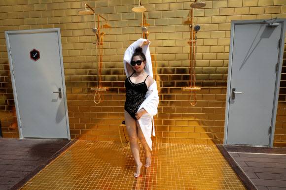 한 여성이 2일(현지시간) 베트남 하노이에 새로 문을 연 ‘돌체 하노이 골든 레이크 호텔’의 금으로 도금한 객실 루프탑 인피니티풀에서 기념촬영을 하고 있다.로이터 연합뉴스