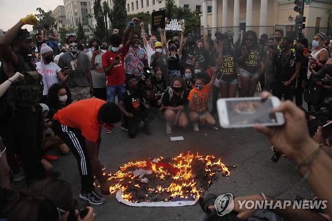독립기념일인 4일(현지시간) 백악관 인근 BLM 플라자에서 성조기를 불태우는 시위대의 모습 [AP=연합뉴스]