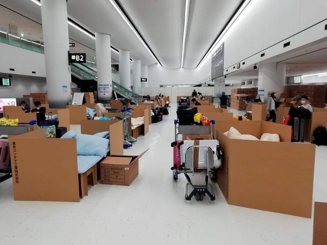 지난 4월 8일 촬영한 사진으로 도쿄의 나리타 국제공항에서 해외 입국자들이 골판지 침대에 누워 코로나19 검사 결과가 나오기를 기다리고 있다. 도쿄=AP 연합뉴스