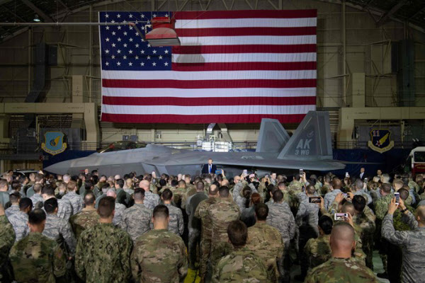 지난 2019년 2월 미 알래스카주 앵커리지 미군기지에서 도널드 트럼프 미 대통령이 성조기와 F-22 전투기 앞에서 연설을 하고 있다. /AFP 연합뉴스