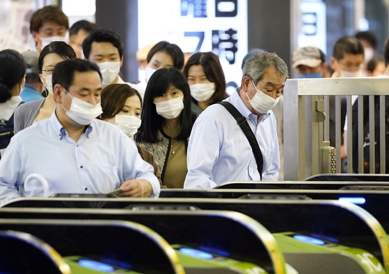 지난 10일 일본 도쿄 신주쿠역에서 마스크를 한 시민들이 개찰구를 빠져나가고 있다. [EPA=연합뉴스]