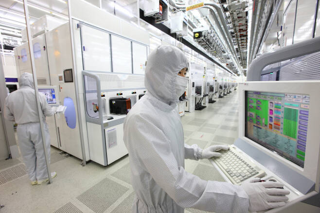 삼성전자 반도체 엔지니어가 반도체가 생산되는 클린룸에서 모니터를 보며 생산설비를 점검하고 있다. [사진 제공 = 삼성전자]