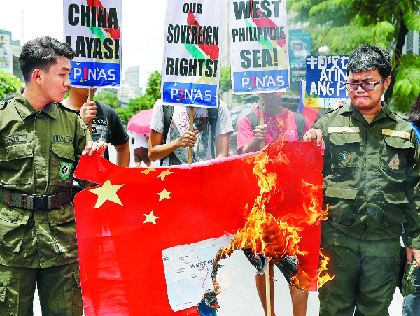 지난달 필리핀 마닐라시내의 중국영사관 근처에서 필리핀 시위대가 중국의 남중국해 점거를 규탄하며 중국 국기를 불태우는 장면이다. AP연합뉴스