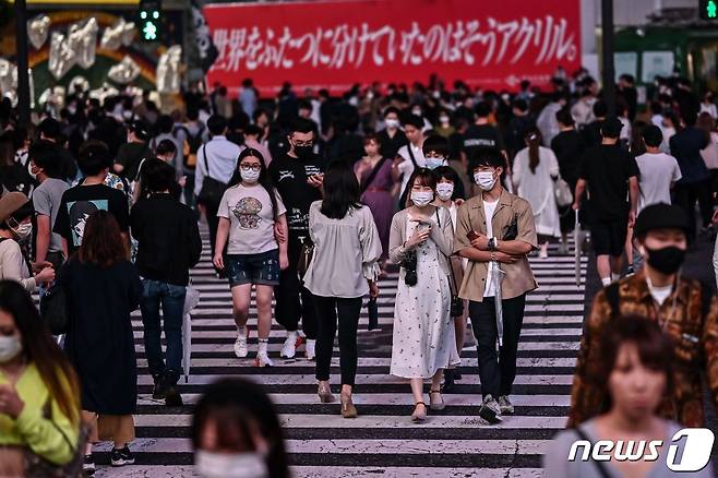 지난 18일 마스크를 쓴 일본 도쿄의 시민들이 횡단보도를 건너가고 있다. © AFP=뉴스1