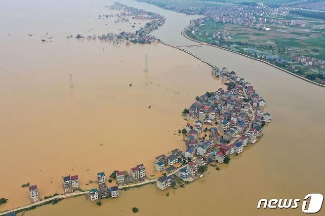 (주장 AFP=뉴스1) 지난 13일(현지시간) 중국 장시성 주장에 폭우로 하천 댐이 무너지면서 물에 잠긴 도로와 건물의 모습이 보인다.  ⓒ AFP=뉴스1