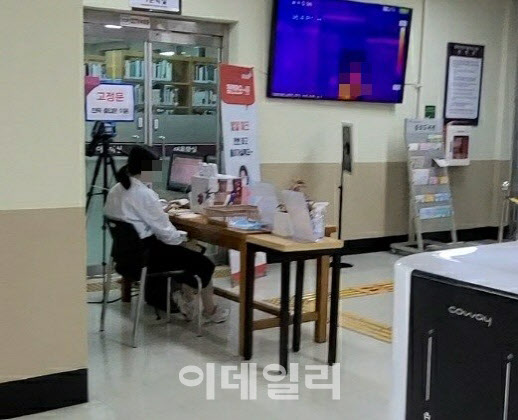 서울 종로구의 한 도서관 입구에 발열체크 및 명단 작성을 돕는 직원이 이용객들을 안내하고 있다.(사진=이용성 기자)