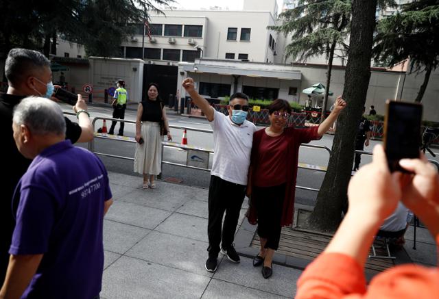 중국이 폐쇄를 요구한 쓰촨성 청두 주재 미국총영사관 건물 입구에서 26일 현지 주민들이 기념사진을 찍고 있다. 청두=로이터 연합뉴스