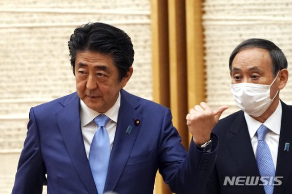 지난 달 아베 신조 일본 총리(왼쪽)가 총리 관저에서 기자회견을 마친 뒤 스가 요시히데 관방장관을 손가락으로 가리키고 있다. AP뉴시스
