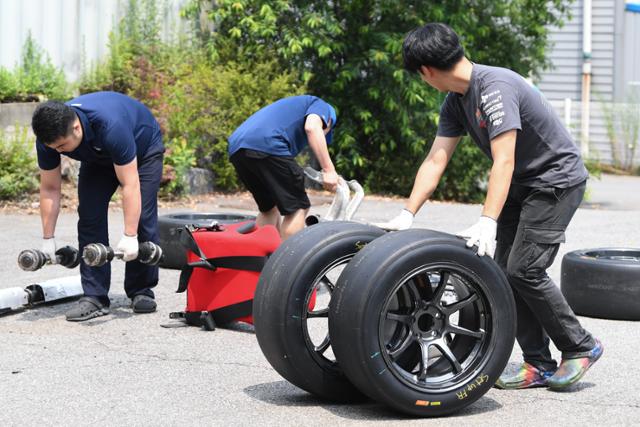 CJ로지스틱스 레이싱팀 미캐닉이 17일 용인 처인구 캠프에서 경기용 차량 타이어와 부품들을 옮기고 있다. 정준희 인턴기자