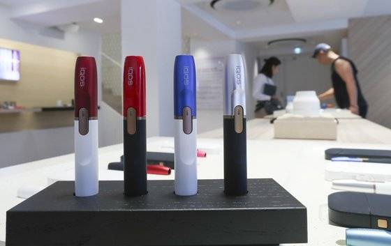 서울의 한 아이코스 매장에서 한 직원들이 고객에게 제품을 안내하고 있다. 중앙포토