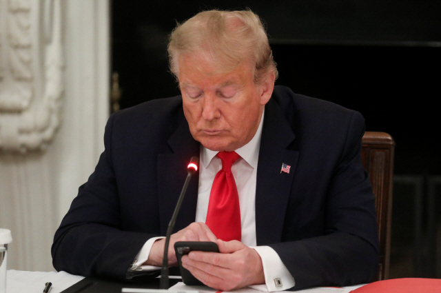 백악관 회의 도중에 휴대폰을 조작하고 있는 도널드 트럼프 대통령 /로이터연합뉴스