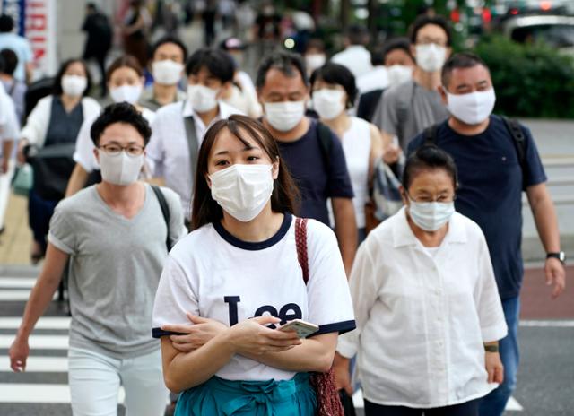 지난달 22일 일본 도쿄의 번화가인 신주쿠에서 마스크를 착용한 시민들이 출근하고 있다. 도쿄=EPA 연합뉴스