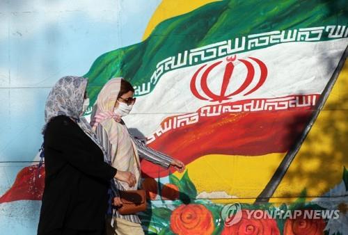 이란 국기가 그려진 벽화앞을 지나가는 테헤란 시민 [EPA=연합뉴스자료사진]