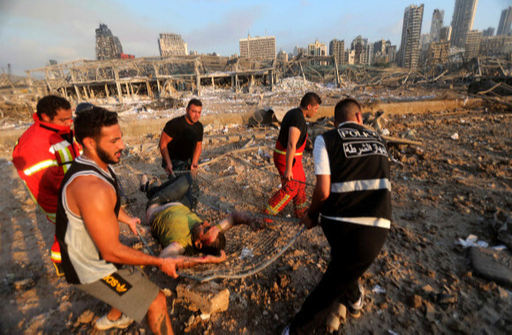 4일(현지시간) 레바논 수도 베이루트 항구의 대규모 폭발 현장에서 소방대원들이 부상자를 들것에 실어 이송하고 있다. 베이루트 AFP=연합뉴스