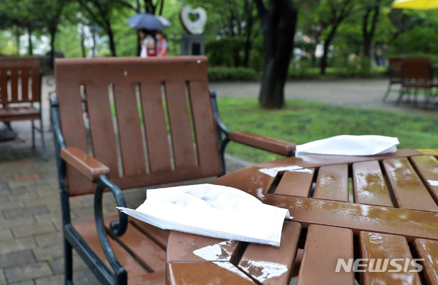 [인천=뉴시스] 이종철 기자 = 비가 오는 5일 오전 인천시 남동구 중앙공원 야외용 테이블에 마스크가 버려져 있다. 2020.08.05. jc4321@newsis.com
