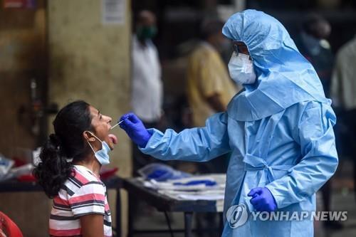 인도 뭄바이에서 코로나19 감염 검사를 하는 의료진(오른쪽). [AFP=연합뉴스]