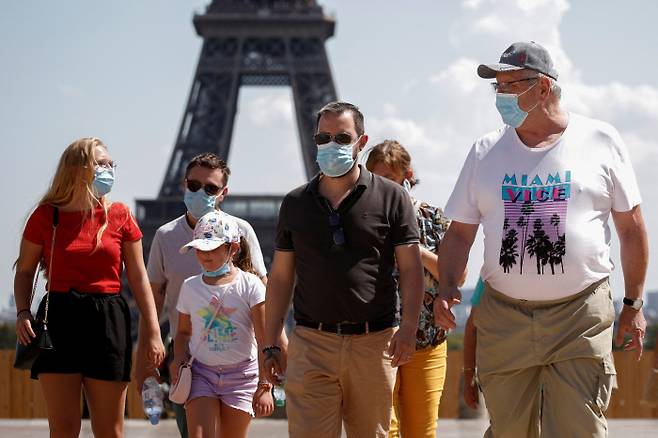 마스크를 쓴 사람들이 프랑스 파리 에펠탑 인근 트로카데로 광장을 지나고 있다. /로이터 연합뉴스
