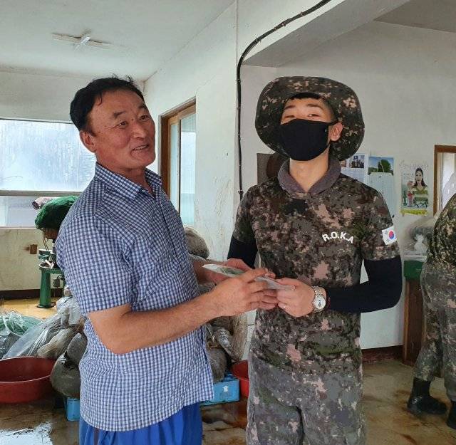 장맛비로 침수된 경남 하동군에서 복구 지원에 나선 육군 39사단 박기수 중사(26·오른쪽)와 수재민 김영철 씨(59·왼쪽)가 만나 이야기를 나누고 있다. 박 중사는 9일 김 씨에게 어머니 유품을 찾아줬다.