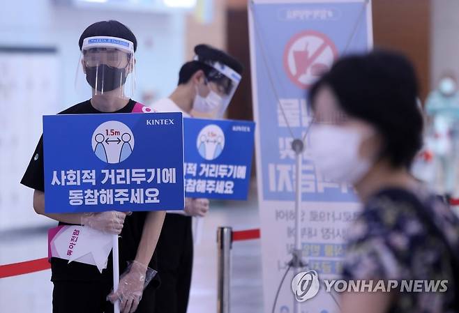 '사회적 거리두기 동참해주세요' (고양=연합뉴스) 김병만 기자 = 20일 경기도 고양시 킨텍스 제1전시장에서 열린 제54회 MBC건축박람회에서 전시장 방역요원들이 '사회적 거리두기' 동참을 유도하고 있다. 이날 행사는 경기 고양시가 '집합금지 명령'을 시행해 취소됐으며 오는 30일까지 각종 전시와 관람 행사도 금지된다. kimb01@yna.co.kr