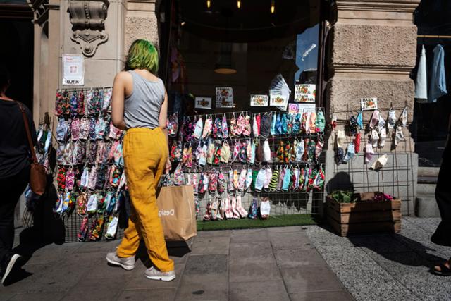 스웨덴 스톡홀름의 한 상점 앞에서 6월 27일 한 여성이 판매 중인 마스크를 바라보고 있다. 스톡홀름=AP 뉴시스