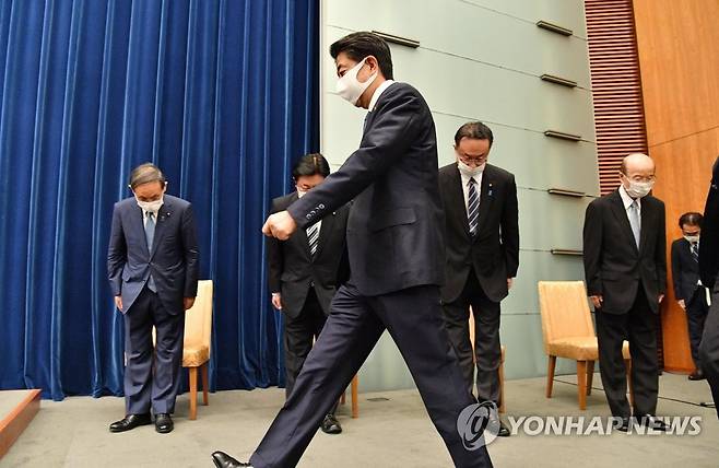 (도쿄 교도=연합뉴스) 아베 신조(安倍晋三) 일본 총리가 지난달 28일 오후 총리관저에서 열린 기자회견장에 입장하고 있다. 스가 요시히데(菅義偉·왼쪽) 관방장관이 고개를 숙여 예의를 표하고 있다.