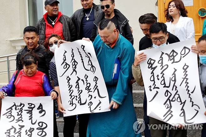 지난달 31일 몽골 울란바토르 외교부 밖에서 몽골어로 쓴 플래카드를 든 시위 참가자들이 중국에 항의하고 있다. [로이터=연합뉴스]