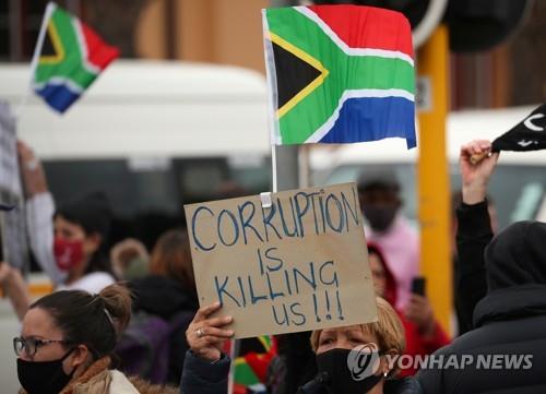 5일 남아공 케이프타운에서 남아공 국기를 든 채 반부패 시위가 벌어지고 있다. [로이터=연합뉴스]