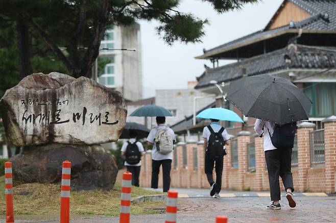 제10호 태풍 '하이선'의 영향권에 든 7일 오전 전남 구례군 구례읍 구례고등학교에서 학생들이 우산을 쓰고 등교하고 있다. [연합]