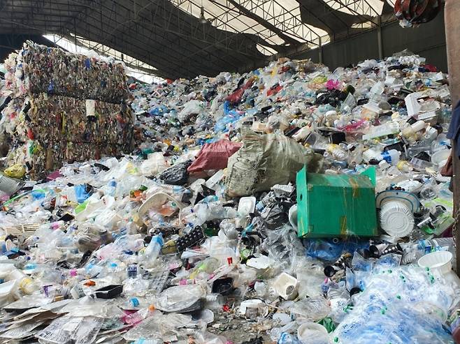 11일 방문한 수도권 종합재활용품선별업체. 입구에 들어서자마자 4미터(m) 이상 쌓인 재활용품 비닐 블록(왼쪽)을 발견할 수 있었다. 블록 뒤로는 아직 선별되지 못한 플라스틱류가 보관돼 있다. /사진=정경훈 기자