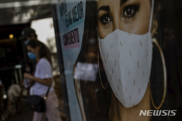 [마드리드=AP/뉴시스]지난달 31일(현지시간) 스페인 마드리드에서 마스크를 쓴 행인들이 한 광고판 앞을 지나고 있다. 2020.09.01.