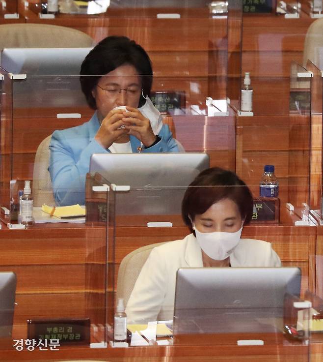 추미애 법무부 장관(뒷줄)이 17일 국회 사회·교육·문화 분야 대정부질문에서 여야 의원들의 질문에 답한 뒤 자리로 돌아가 마스크를 벗고 물을 마시고 있다. 김영민 기자 viola@kyunghyang.com