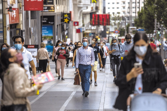 17일(현지시간) 스페인 수도 마드리드 시민들이 모두 마스크를 착용한 채 거리를 걷고 있다. 국제통계사이트 월드오미터에 따르면 이날 스페인의 코로나19 신규 확진자 수는 1만1291명을 기록하며 전날(1만1193명)에 이어 이틀 연속 1만명 선을 돌파했다. [AP]