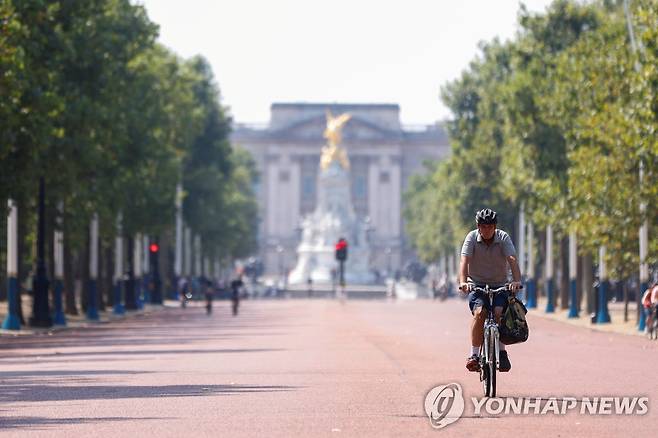 런던 버킹엄궁 앞으로 나 있는 '더 몰'을 자전거를 타고 지나가는 남성 [로이터=연합뉴스]